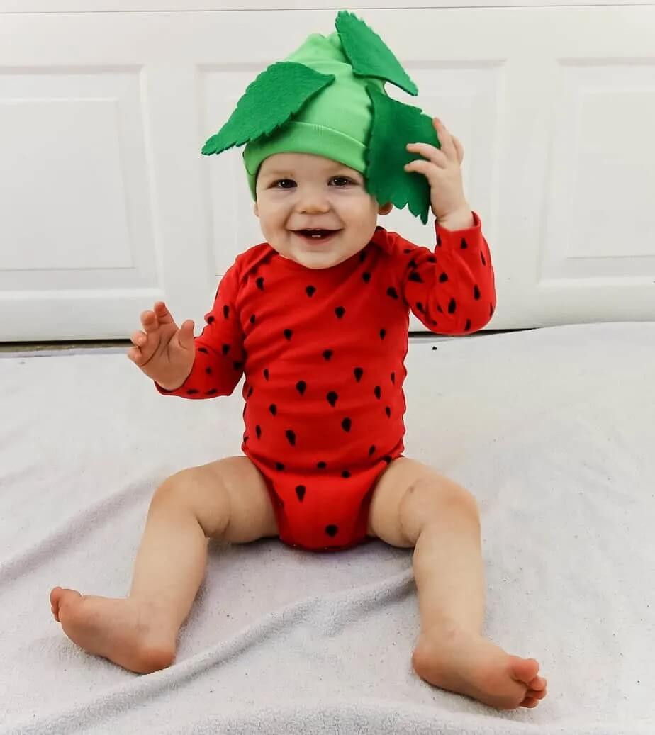 adorable baby dressed as a strawberry with a homemade costume for halloween.