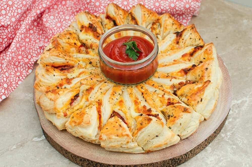 puff pastry pizza wheel with dipping sauce in the centre