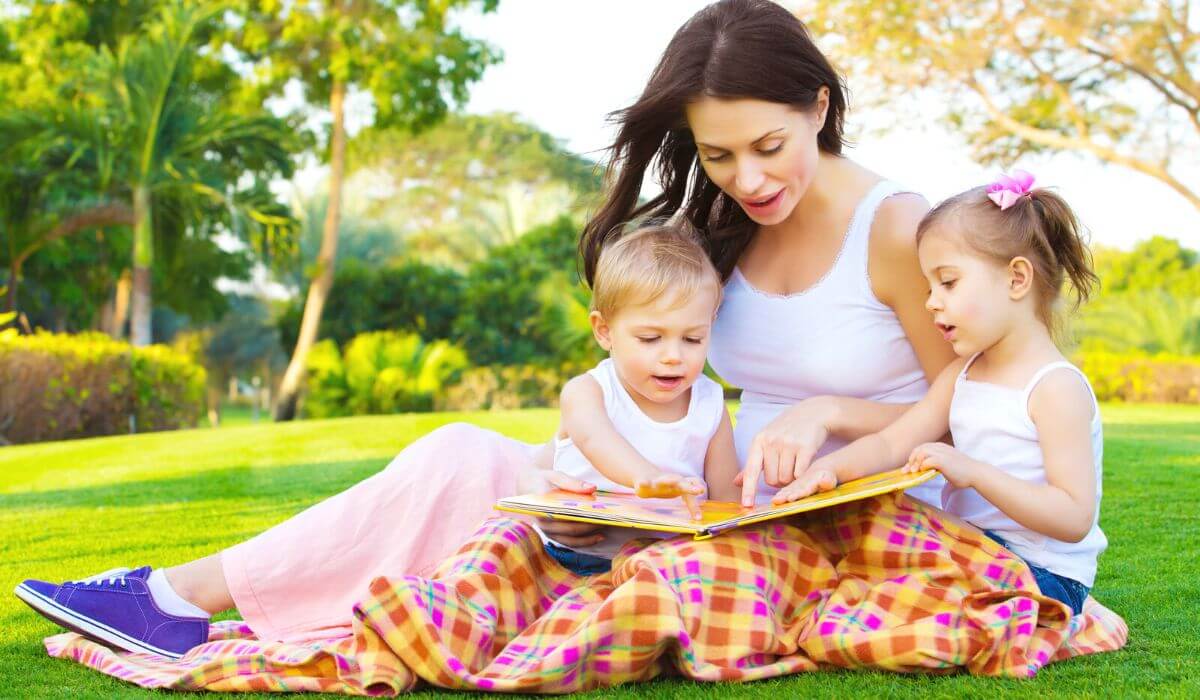 mother reading a picture book with her 2 kids