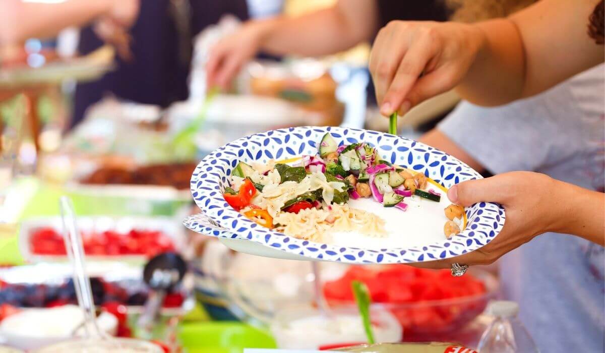 person serving themselves from a party food buffet