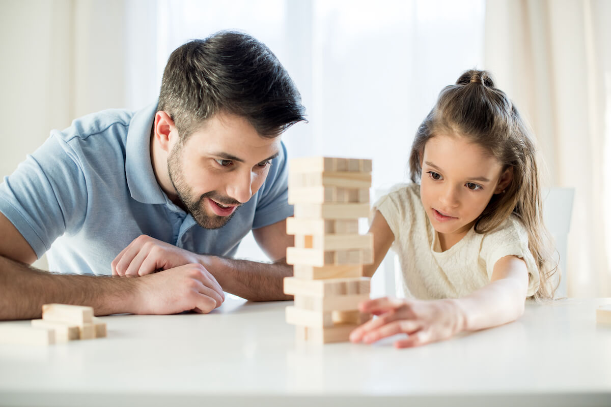 father and daughter playing jenga