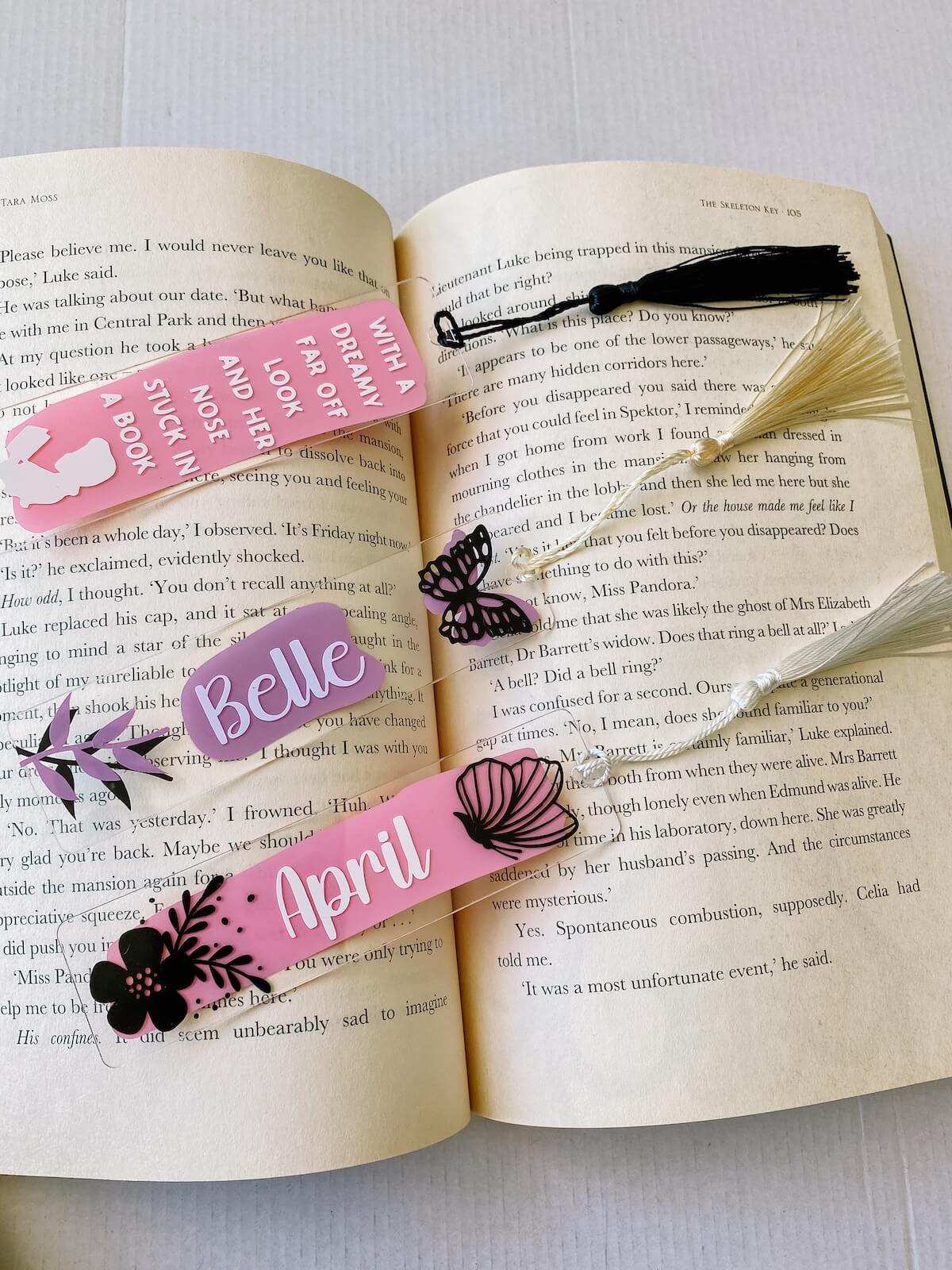 3 personalised diy acrylic bookmarks inside an open book. 