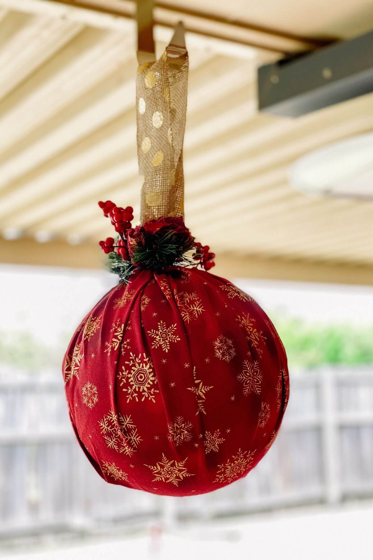 oversized christmas ornament hanging from patio roof