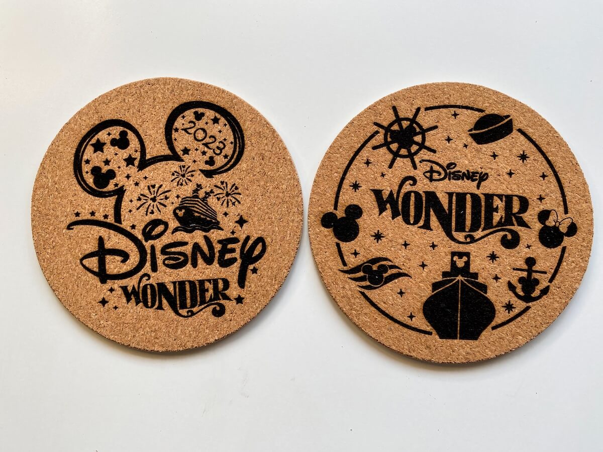 two laser engraved cork coasters with disney wonder images.