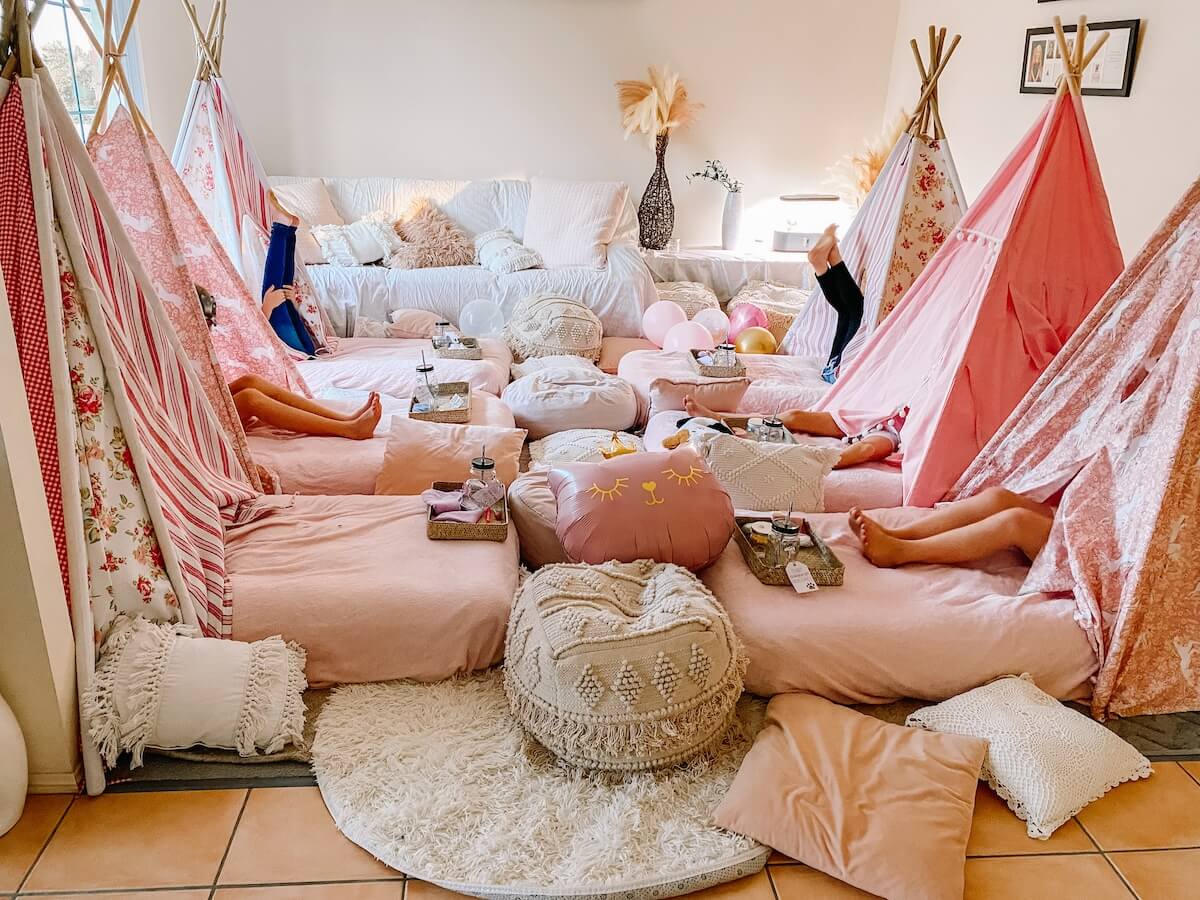 young girls hiding inside their glamping tents at a teepee party sleepover.