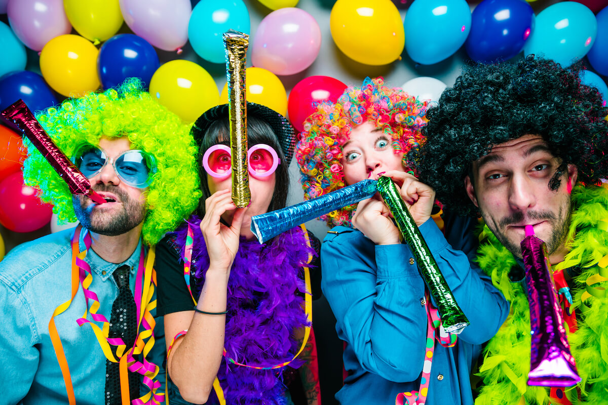 group of friends dressed up for a thene party with wigs and balloons