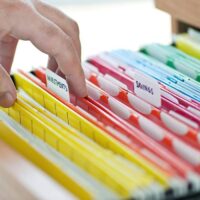 person sorting through filing cabinet