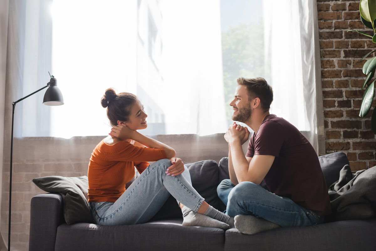 a couple sitting on the couch talking together