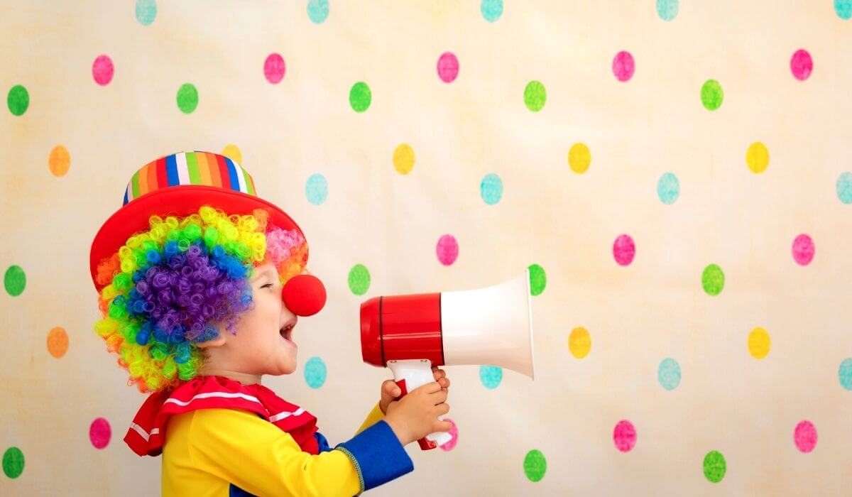 child dressed as a clown with a loud speaker