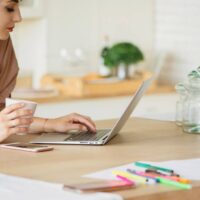 woman working on her laptop in the kitchen