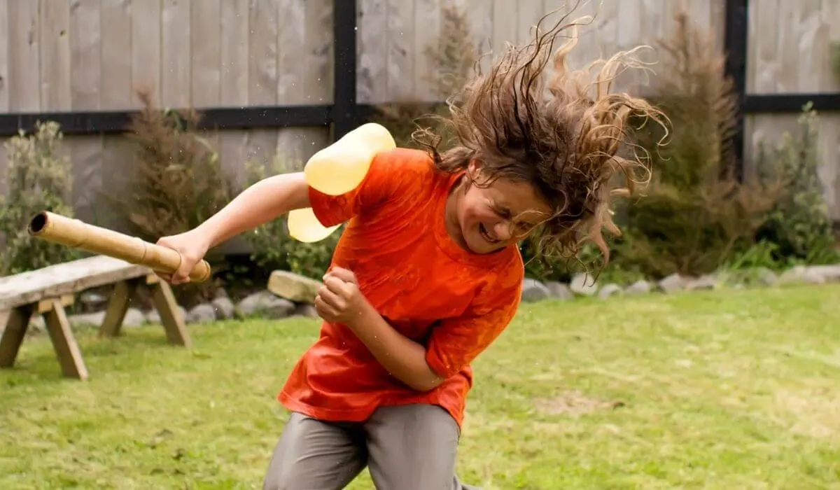 boy hit with water balloon while playing a game