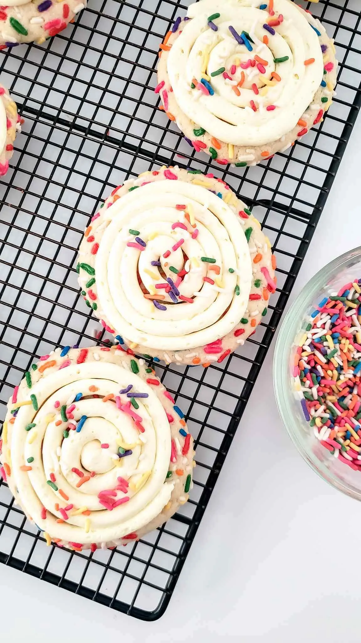 birthday cake crumbl cookies on a wire tray