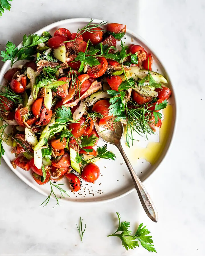 cherry tomato salad on serving platter with spoon