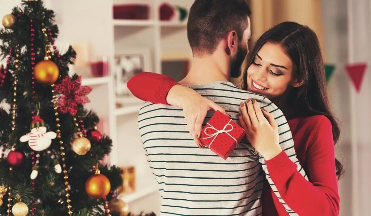 man and woman exchanging christmas gift