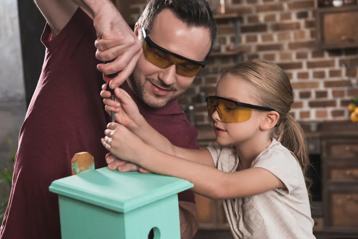 father and daughter working together to make a bird house