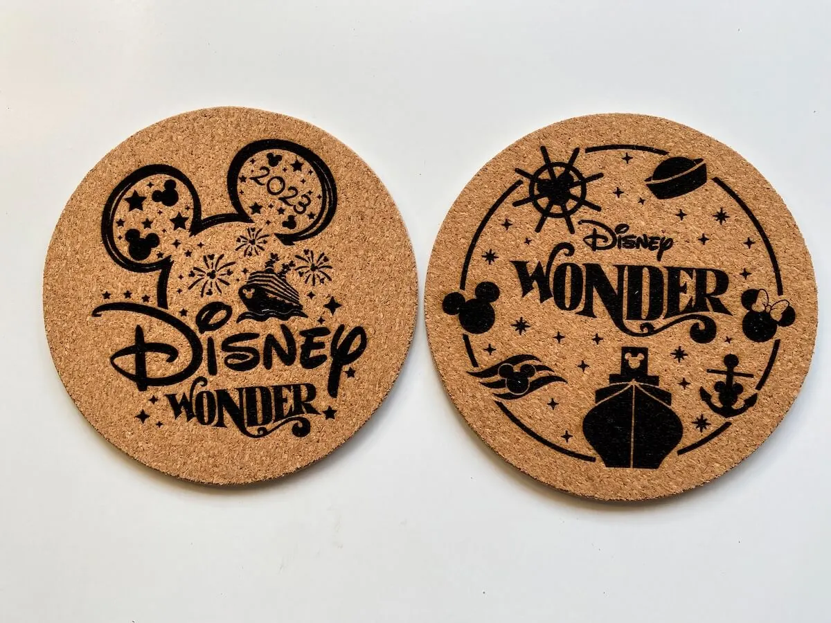 two laser engraved cork coasters with disney wonder images.