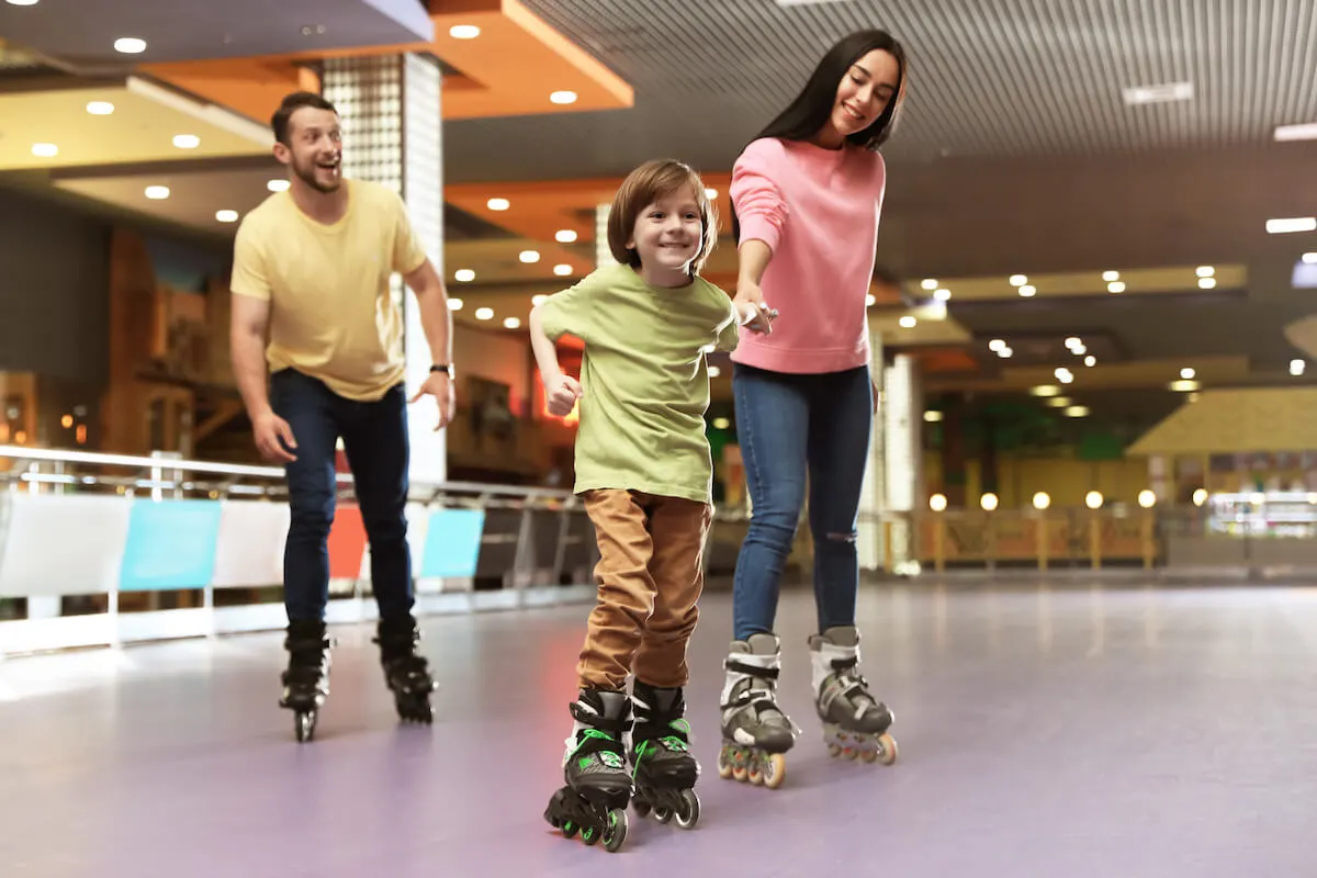 mother father and son at rollerskating rink in rollerblades