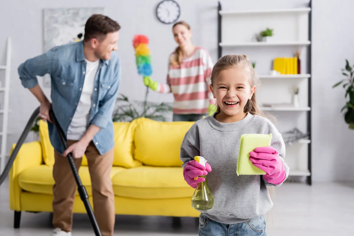 husband wife and daughter cleaning their house together