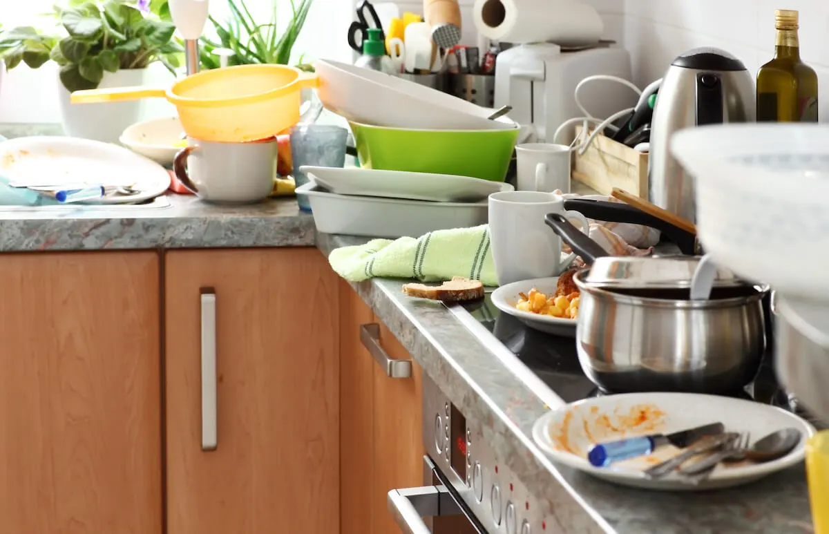 kitchen counters and sink stacked with dirty dishes