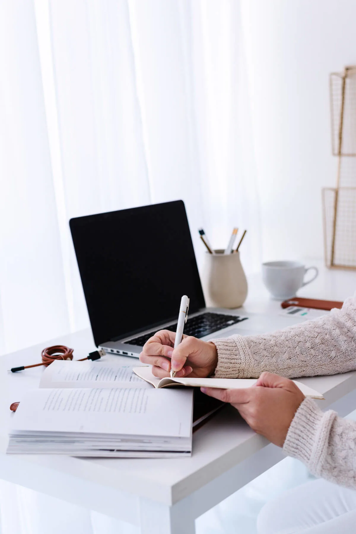 woman at desk writing in planner