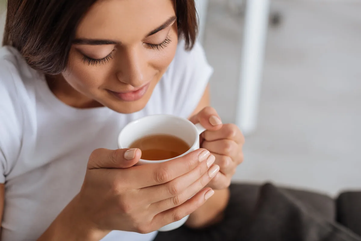 beautiful woman enhaling the scent of her morning coffee