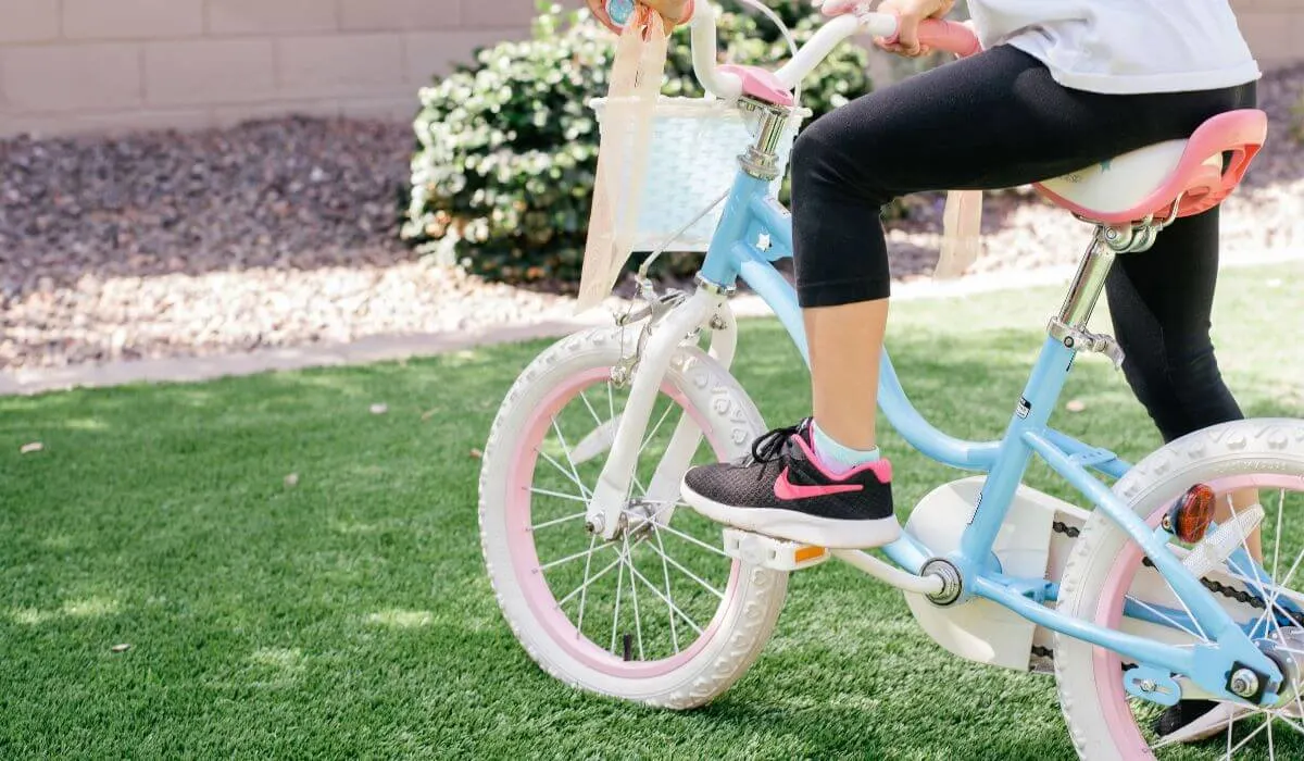 child on bike with basket in backyard