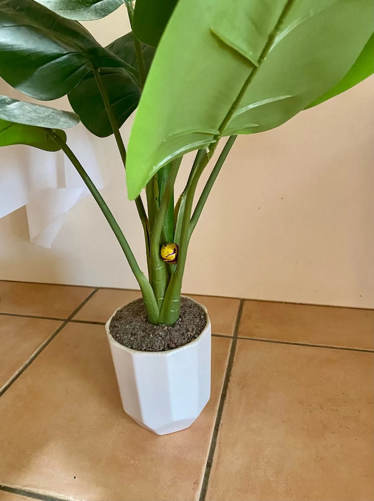 easter egg hidden in stem of a fake plant