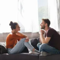 a couple sitting on the couch talking together