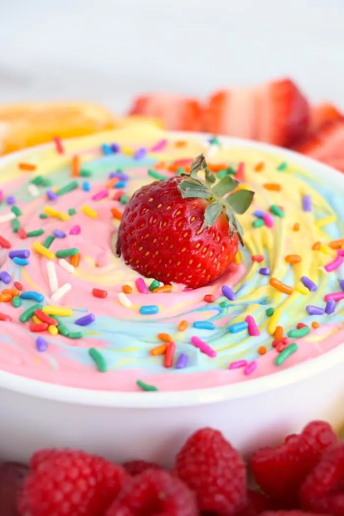 close up of bowl of fruit dip with strawberries