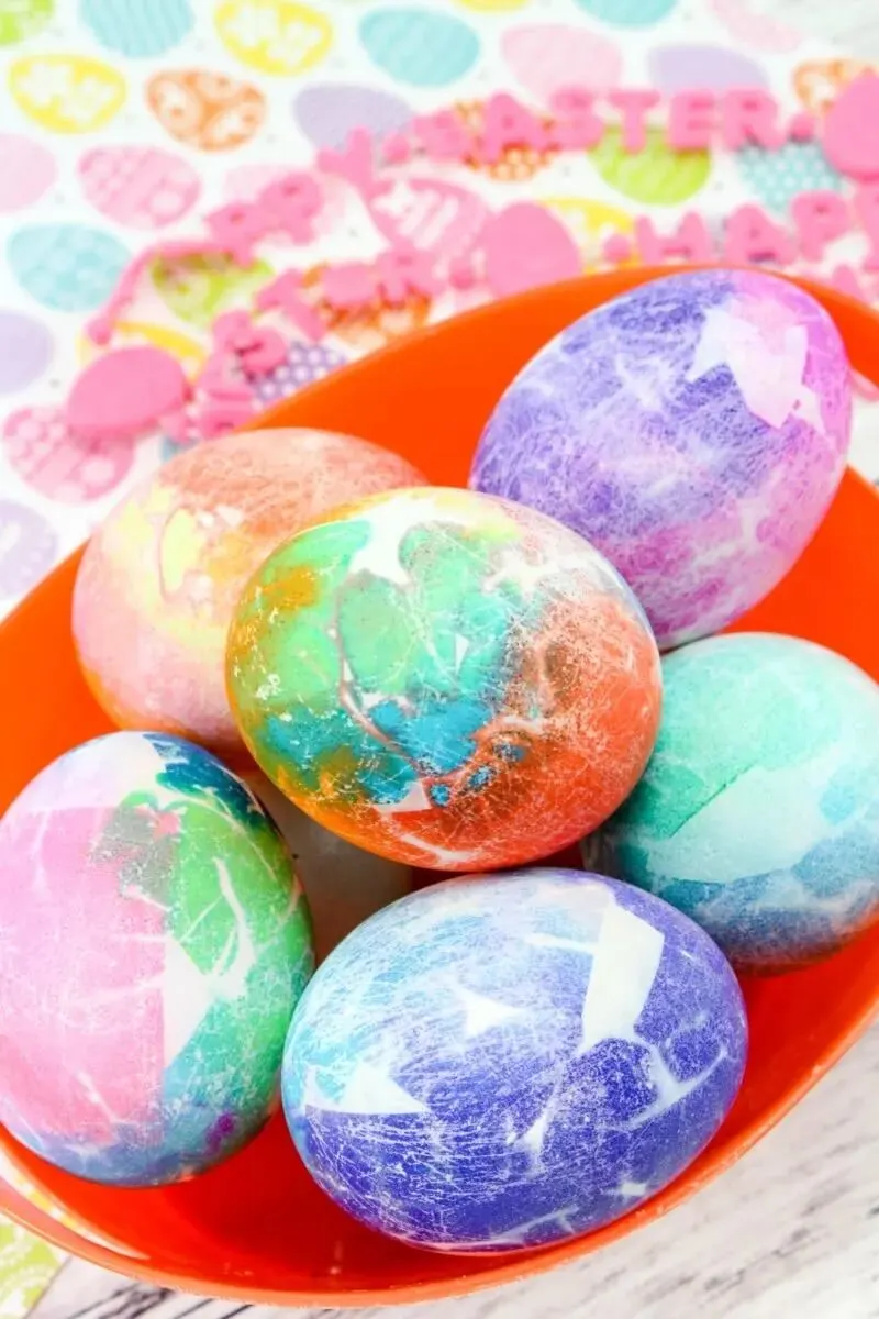 tissue paper dyed easter eggs in a red bowl